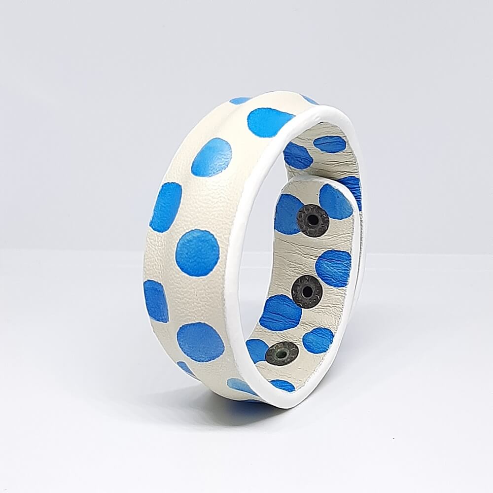 bracciale in pelle bianco con design a pois blu e bordatura centrale