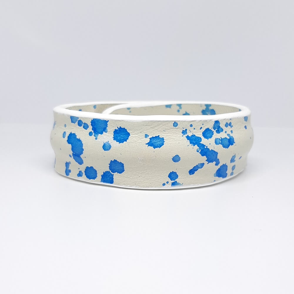 bracciale in pelle bianco con design a schizzo blu e bordatura centrale