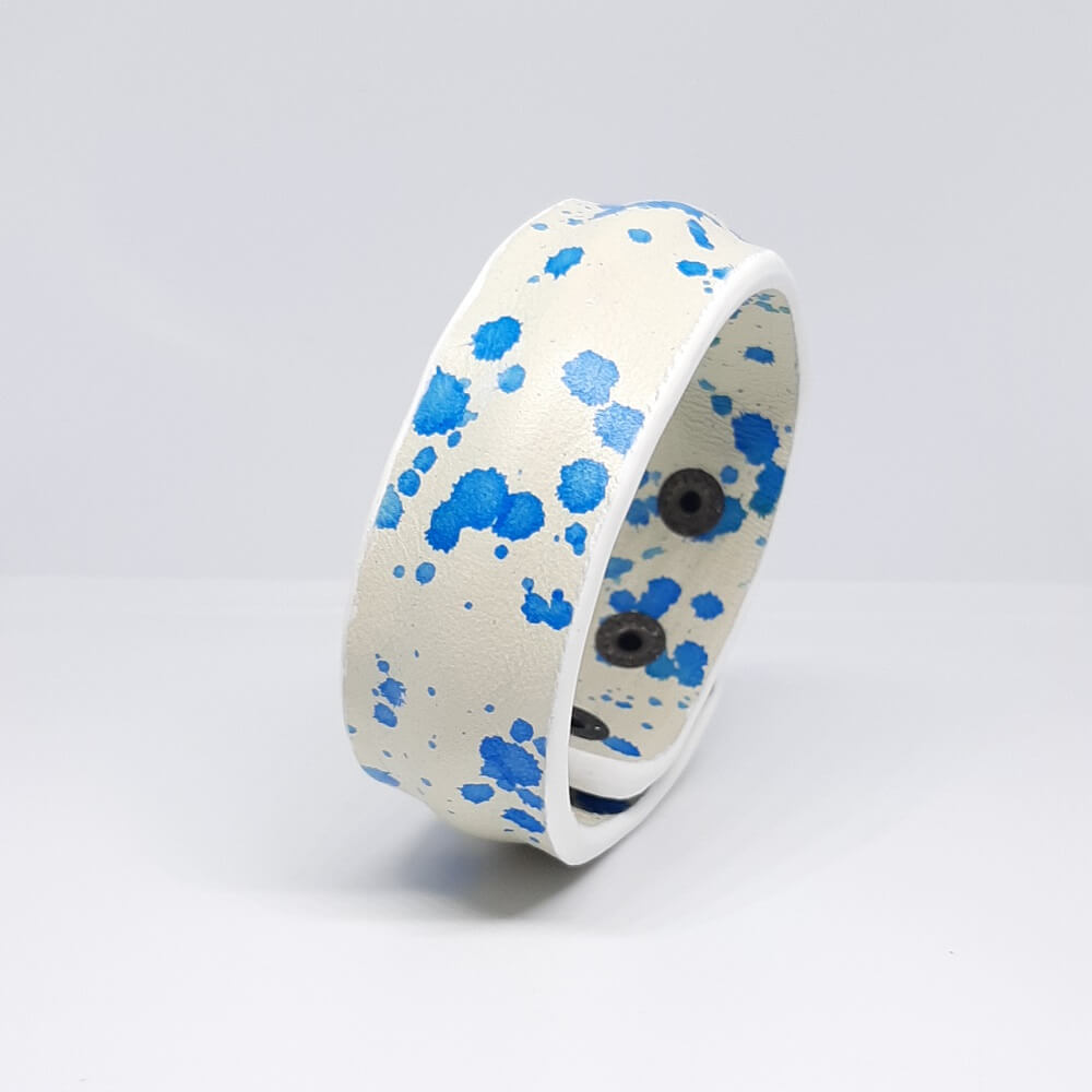 bracciale in pelle bianco con design a schizzo blu e bordatura centrale